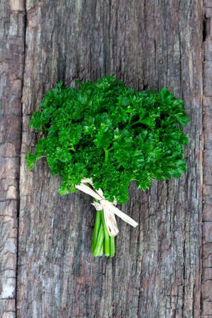 tied fresh parsley on wooden surfaceの写真素材