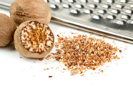 nutmeg with grinder isolated on whiteの写真素材