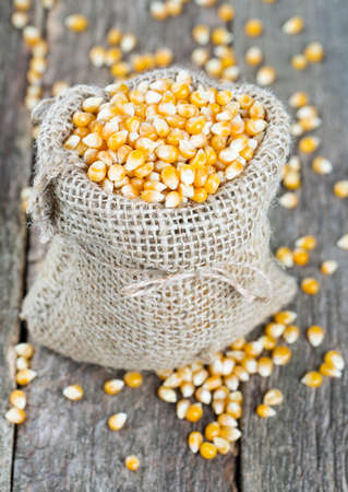 corn in burlap bag on wooden surfaceの写真素材