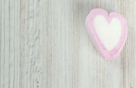 heart-shaped marshmallow on wooden surface