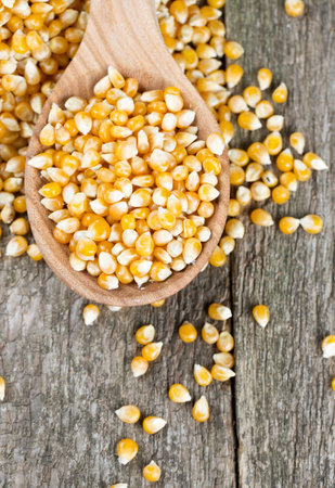 corn in wooden spoon on rustic surface