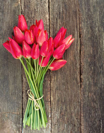 bunch of red tulips on wooden surfaceの写真素材