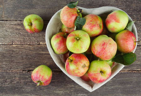 apples in a basket on wooden surfaceの写真素材