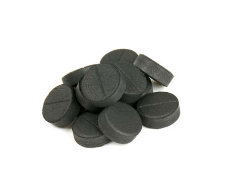 black pills (activated coal) isolated on whiteの写真素材