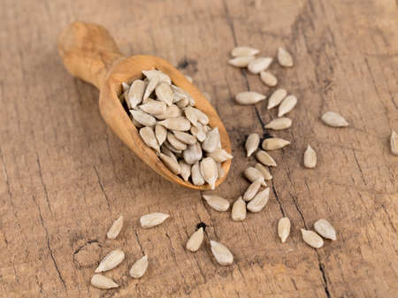 sunflower seeds in a wooden spoonの写真素材