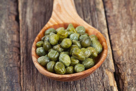 capers in a wooden spoonの写真素材