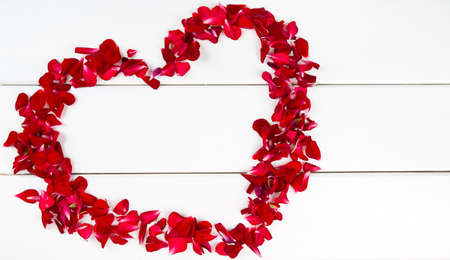 heart made of petals on wooden surfaceの写真素材