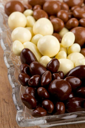 chocolate covered nuts and raisins on wooden surface