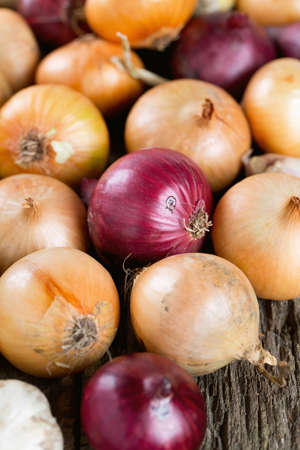 red and yellow onion on wooden surfaceの写真素材