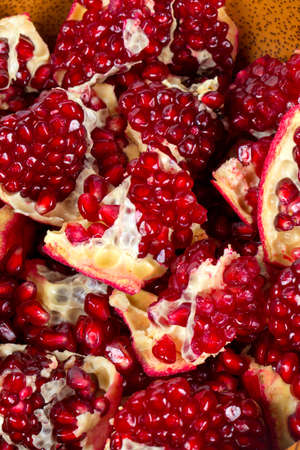 broken pomegranate in a wooden bowl