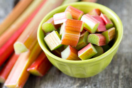 freshly cut pieces of rhubarb on wooden surfaceの写真素材