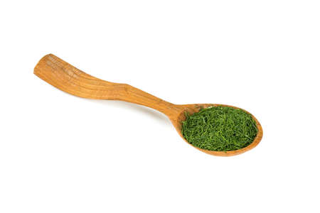 dried dill in a wooden spoon isolatedの写真素材