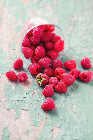 raspberry in a glass bowl on wooden surfaceの写真素材