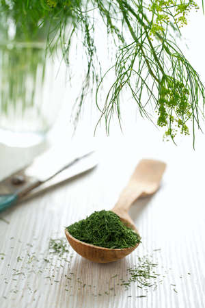 dried dill in a wooden spoonの写真素材