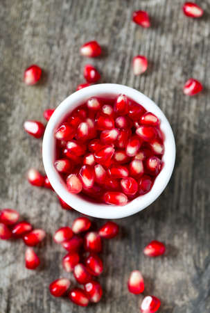pomegranate seeds on wooden surfaceの写真素材