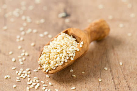 sesame seeds in a wooden scoopの写真素材