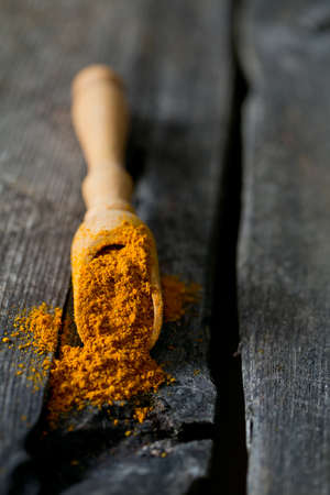 curry powder on wooden surfaceの写真素材