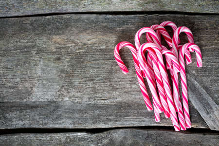 Striped Christmas candies on wooden surfaceの写真素材