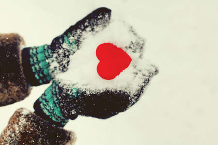 red heart in warm gloves