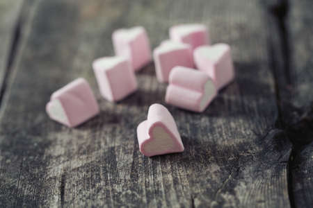 heart-shaped marshmallows on wooden surface