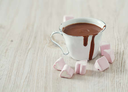 hot chocolate and heart-shaped marshmallow on wooden table