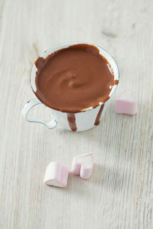 hot chocolate and heart-shaped marshmallow on wooden table