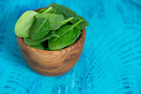 spinach in a bowl on wooden surface