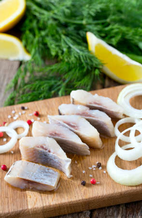 herring onion and herbs on wooden surfaceの写真素材