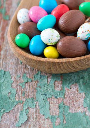 Easter candy eggs on old wooden surface