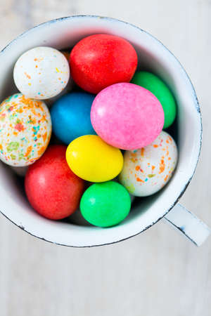 Easter candy eggs on white wooden surfaeの写真素材