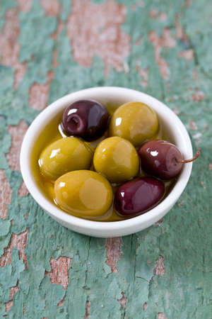 olives in a bowl on wooden surfaceの写真素材