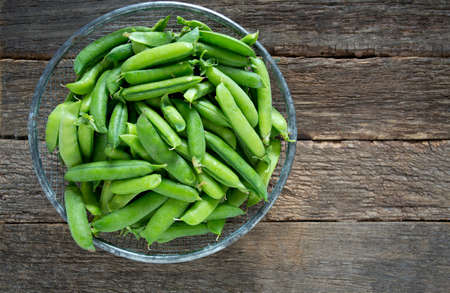 pea pods on wooden surfaceの写真素材