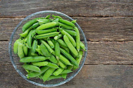 pea pods on wooden surfaceの写真素材