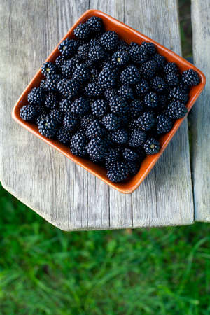 blackberries in a bowl on wooden surfaceの写真素材
