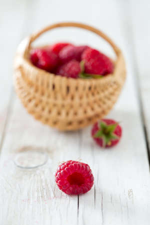 raspberries in a basket on wooden surface