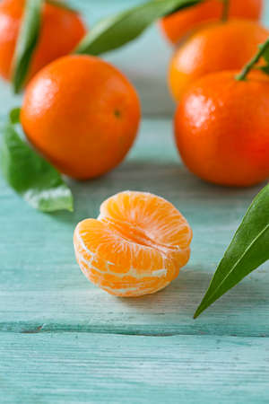tangerines with green leaves on turquoise wooden backgroundの写真素材