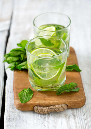 Mojito and ingredients on white wooden surfaceの写真素材