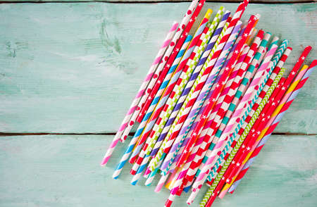 multicolored paper straws on turquoise wooden backgroundの写真素材