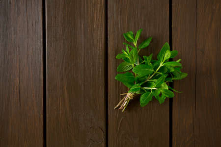 bunch of mint leaves on wooden surfaceの写真素材