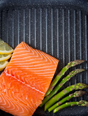 salmon fillet and asparagus on panの写真素材