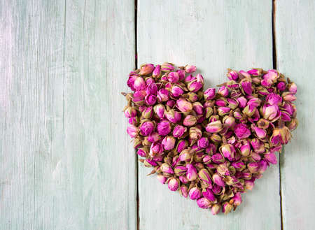 dried rose buds on turquoise wooden surfaceの写真素材