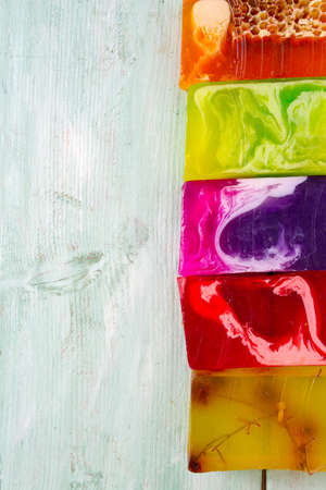 colorful hand made soap bars on turuoise wooden surfaceの写真素材
