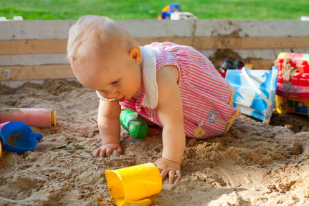 baby girl having fun in sand boxの写真素材