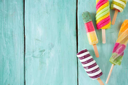 colorful popsicle ice cream on turquoise wooden backgroundの写真素材