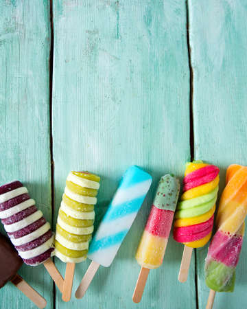 colorful popsicle ice cream on turquoise wooden background