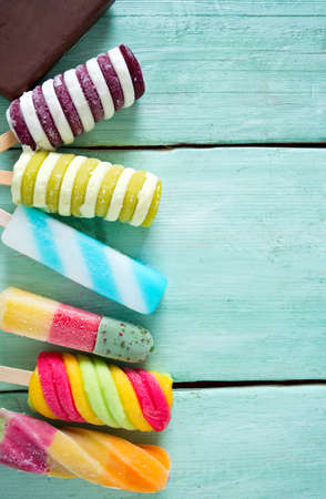 colorful popsicle ice cream on turquoise wooden background
