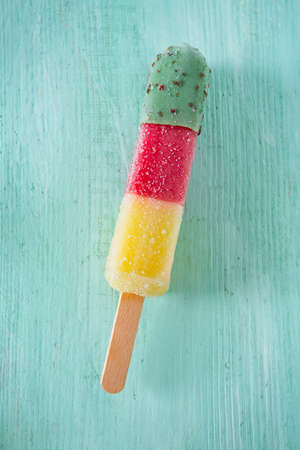 colorful popsicle ice cream on turquoise wooden backgroundの写真素材