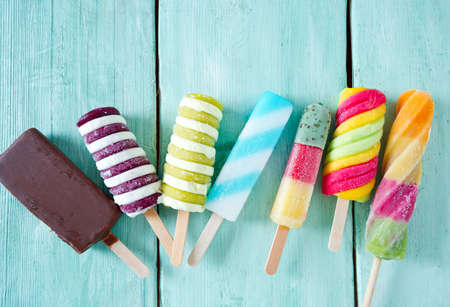 colorful popsicle ice cream on turquoise wooden backgroundの写真素材