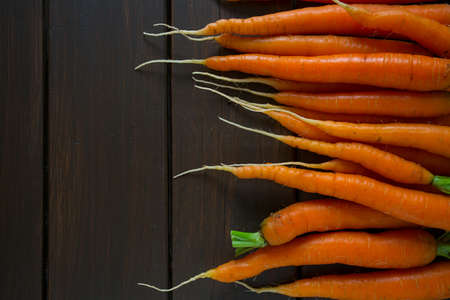 fresh carrots on wooden surface
