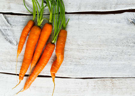 fresh carrots on wooden surfaceの写真素材